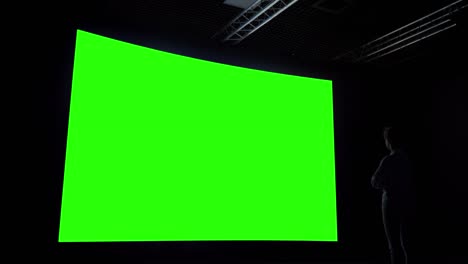woman looking at blank large interactive wall display - green screen concept