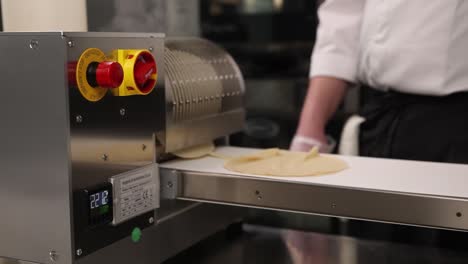 chef using a commercial pastry dough rolling machine