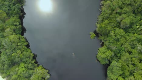 drone footage of woman swimming in black water lake