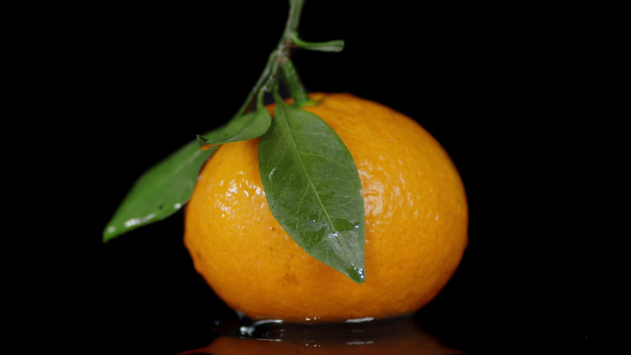 una mandarina fresca con hojas gira lentamente.