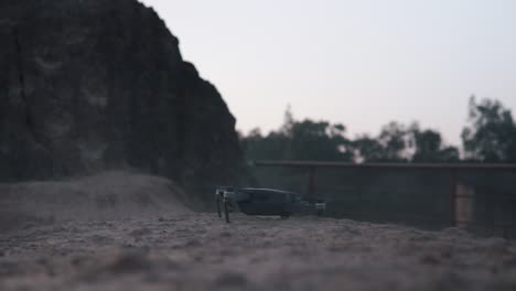 small drone taking off from a rock cliff surface