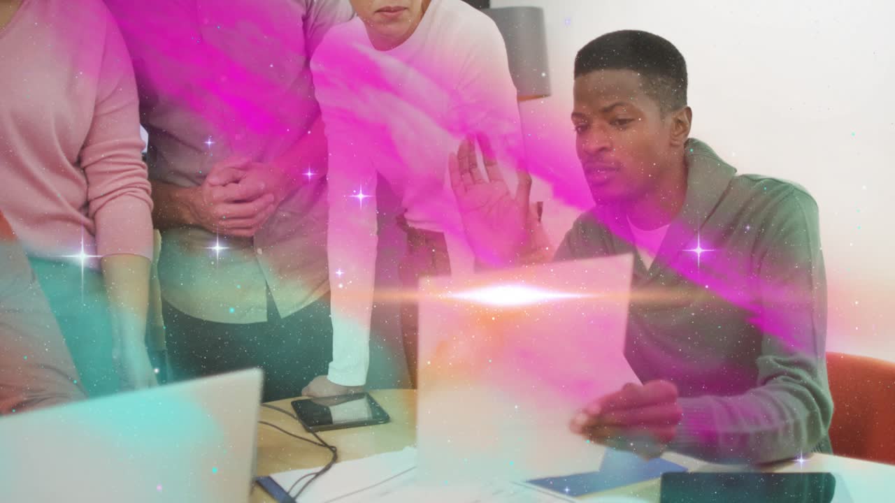Seated man in green hoodie grabbing sheet guiding business review with pink teal streaks overlaying