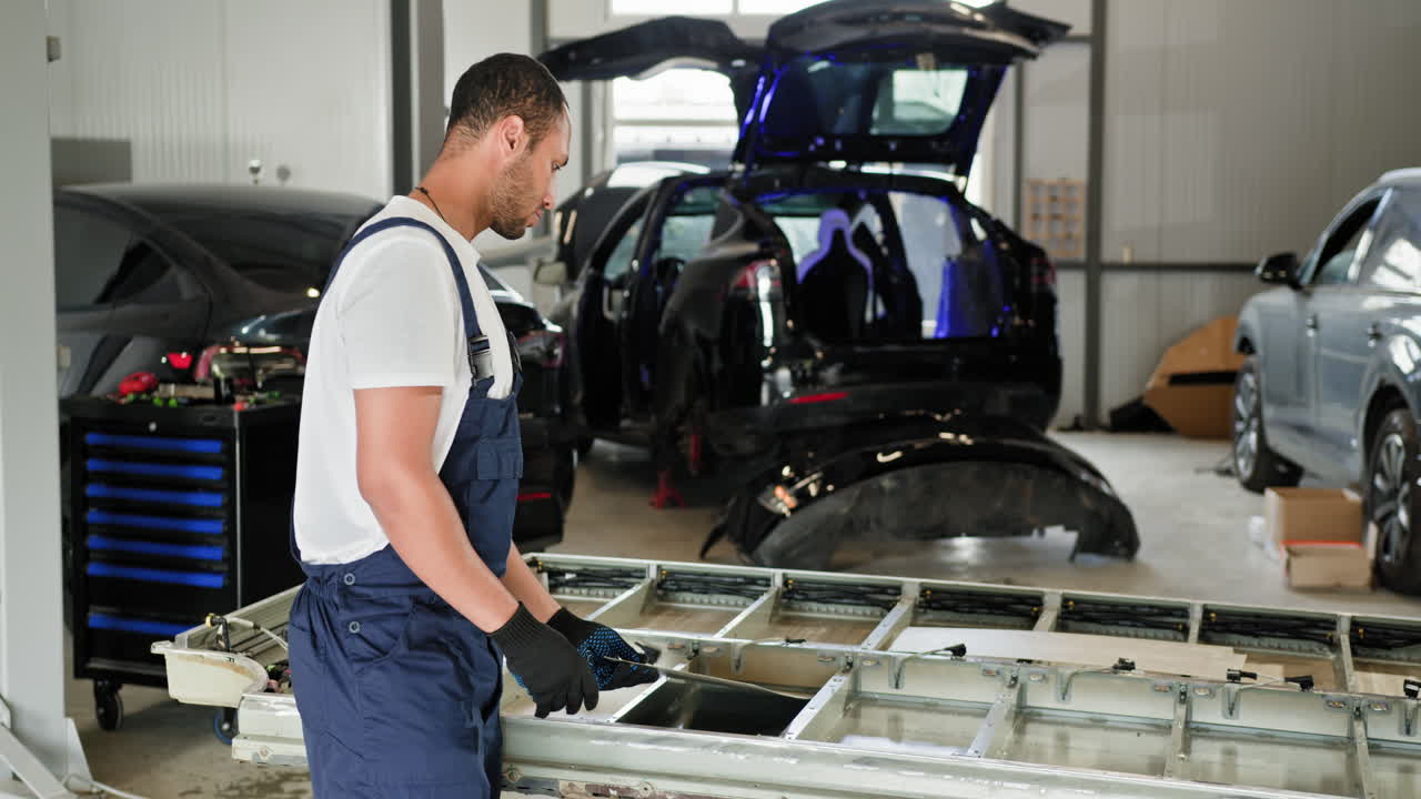 mecánico de automóviles que repara piezas de automóviles en el garaje