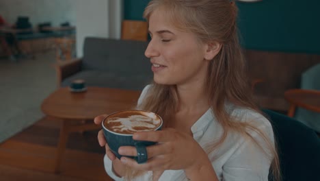 mujer disfrutando de un latte en un acogedor café