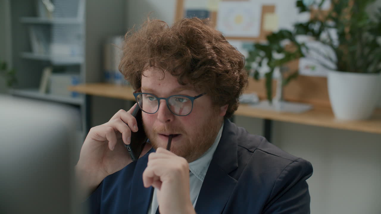 Imprenditore che parla al telefono e prende appunti sul posto di lavoro in ufficio.