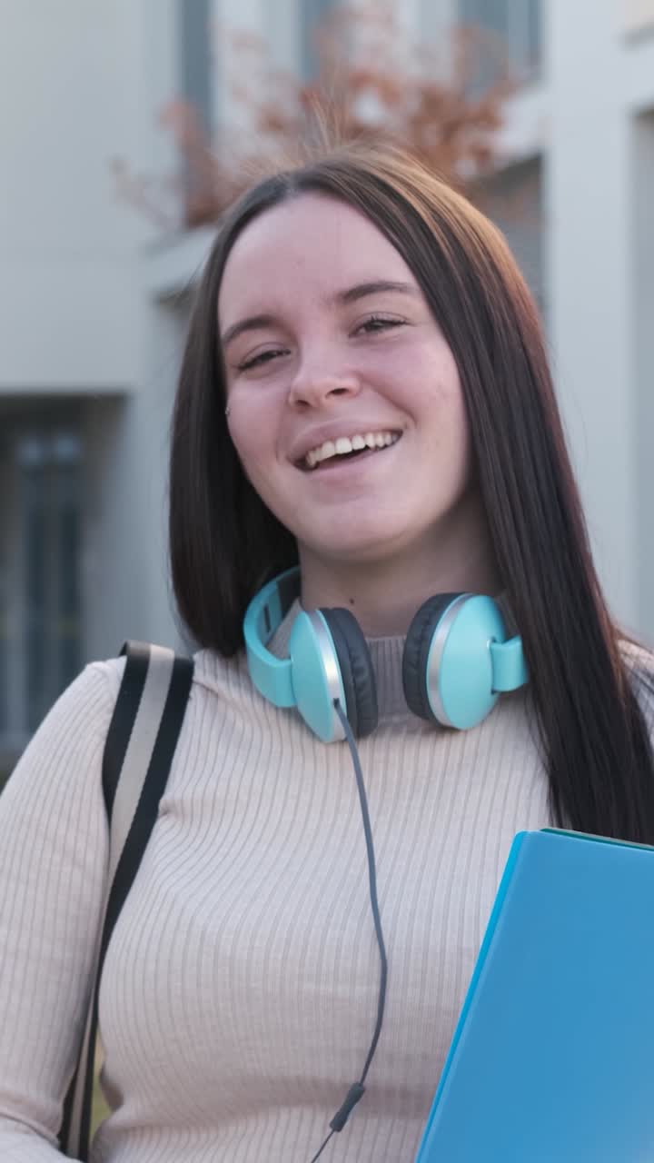 Studentessa felice che sorride alla telecamera