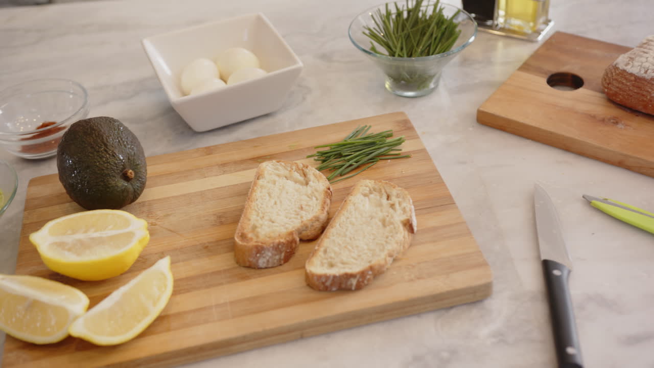 Preparing healthy meal, slicing bread and vegetables on kitchen counter