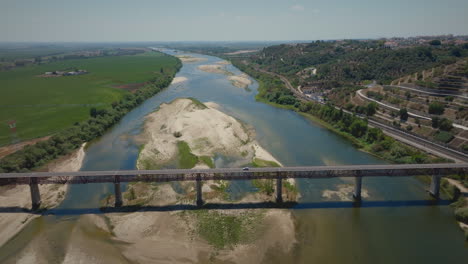 Dry-river-in-summer-over-a-bridge-medium-aerial-shot