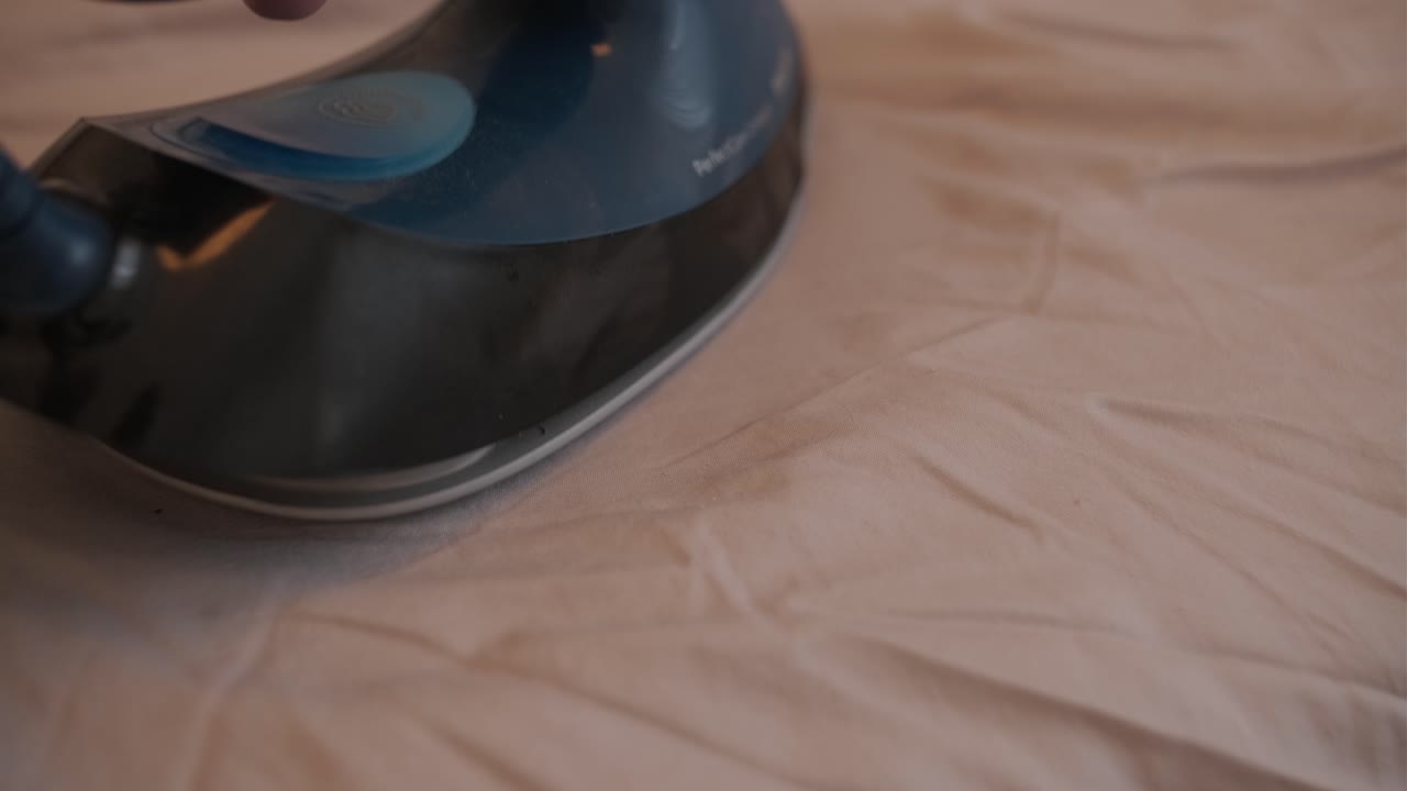 Steam Iron Releasing Vapor on Wrinkled Fabric