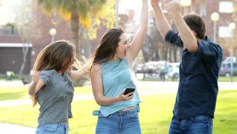 excited friends jumping after checking phone content