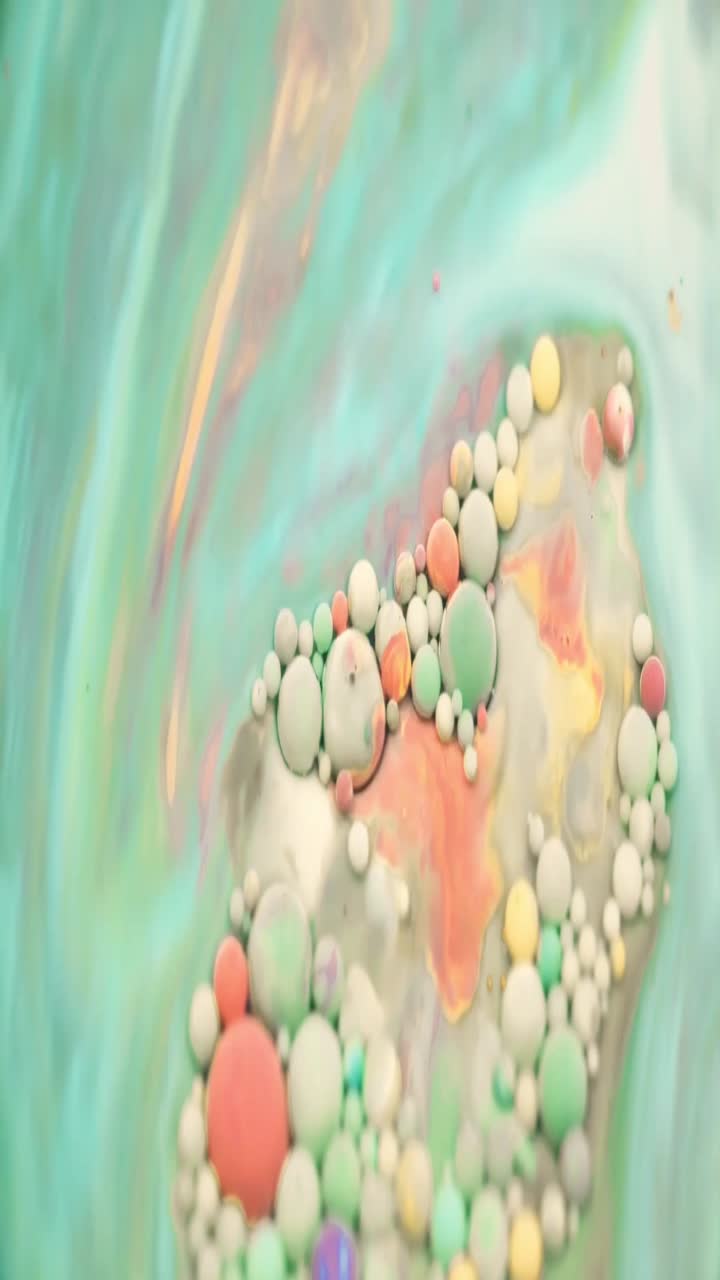 Bolle di pittura colorate che fluttuano e turbinano in un liquido astratto