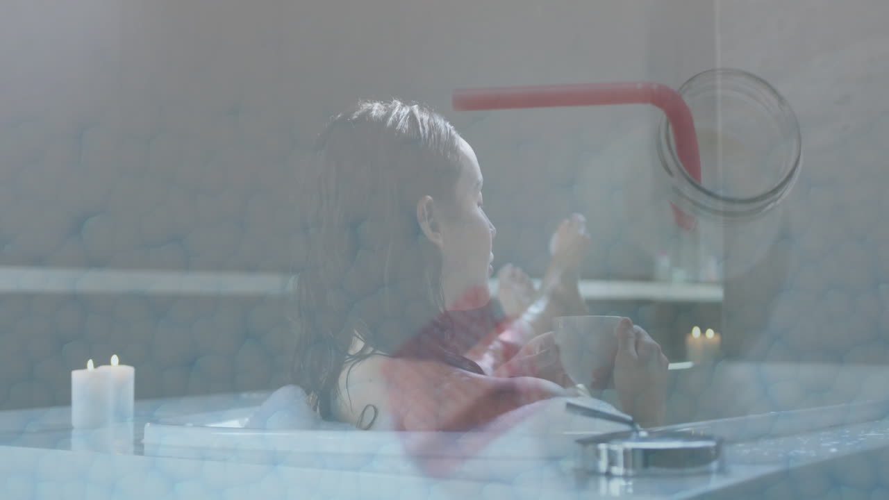 Relaxing in bathtub, woman drinking from cup with candlelight ambiance