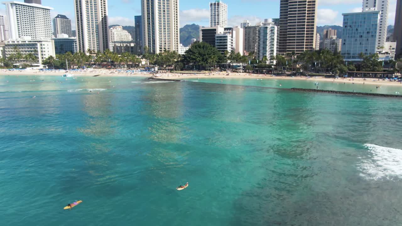 Vista della spiaggia di Waikiki, persone con longboard in acqua turchese, Hawaii