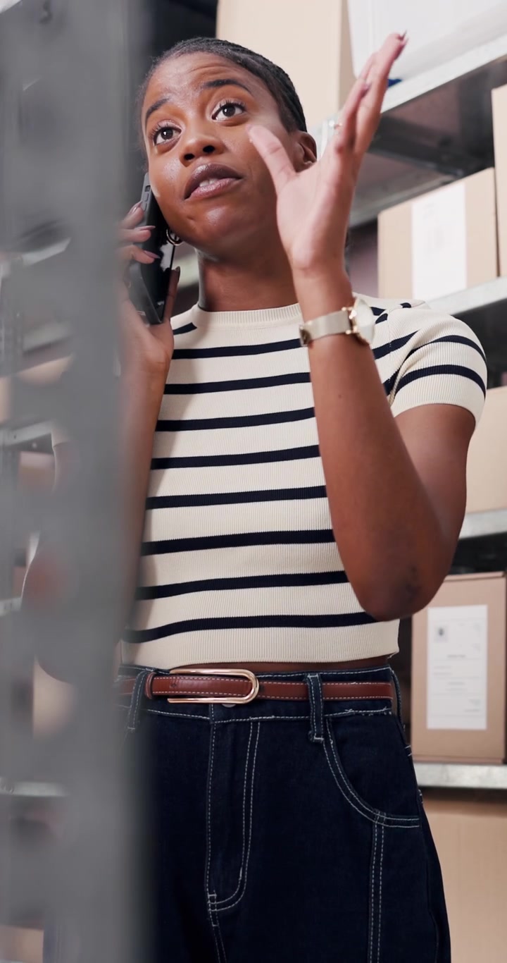 Young Woman Talking on Smartphone in Warehouse