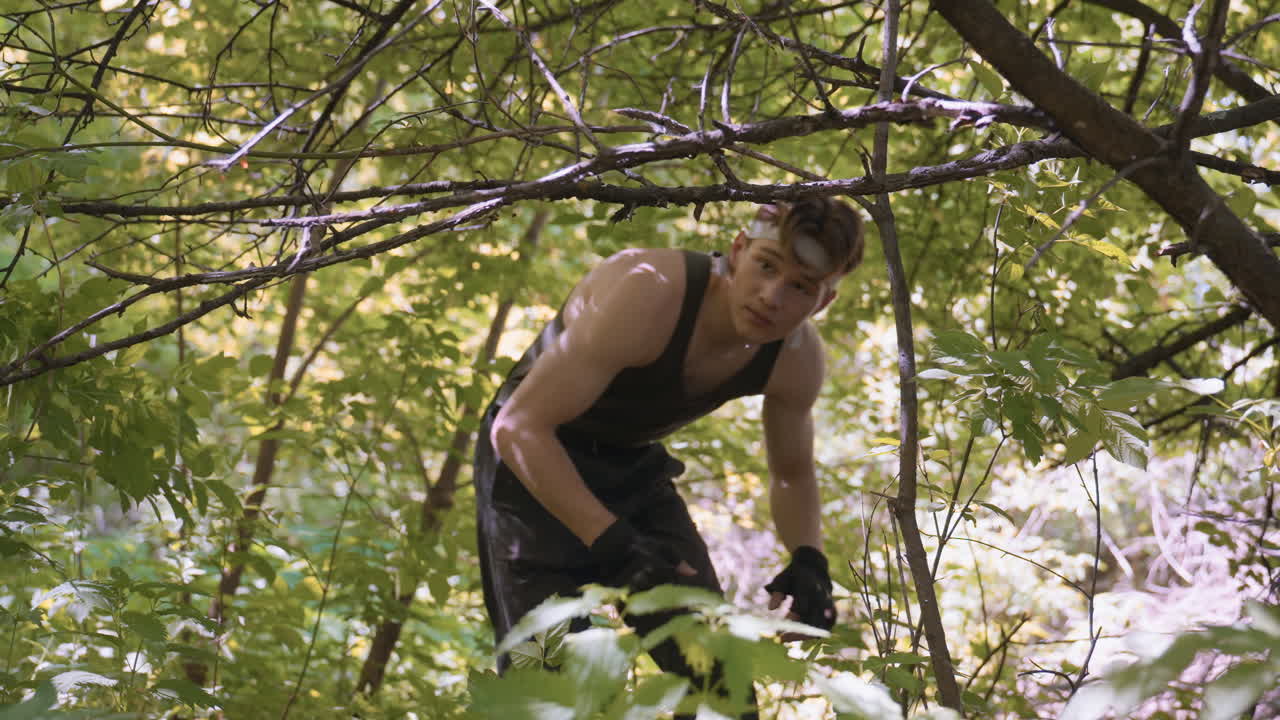 adventurer bending under low hanging branch to prevent head and back scratching while navigating dense forest, muscles tensed, posture low, light filtering through leaves casting moving shadows