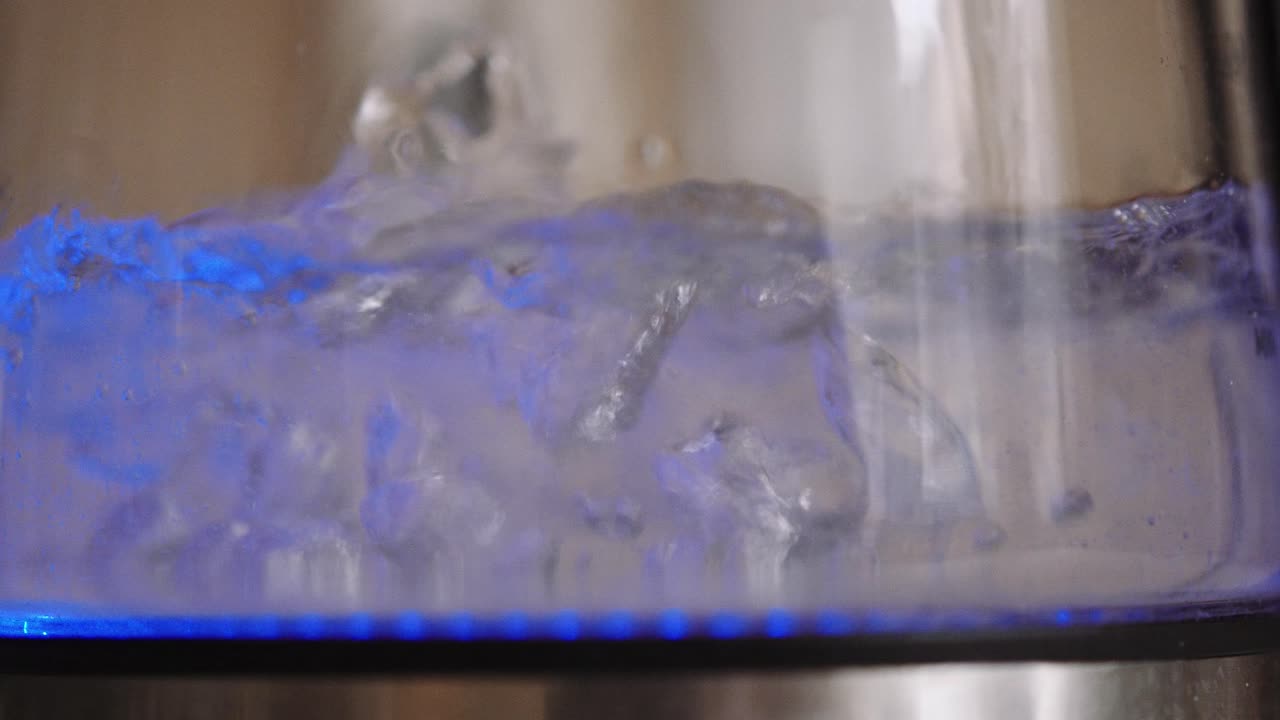 agua hirviendo dentro de una botella iluminada, primer plano de enfoque superficial, cámara lenta