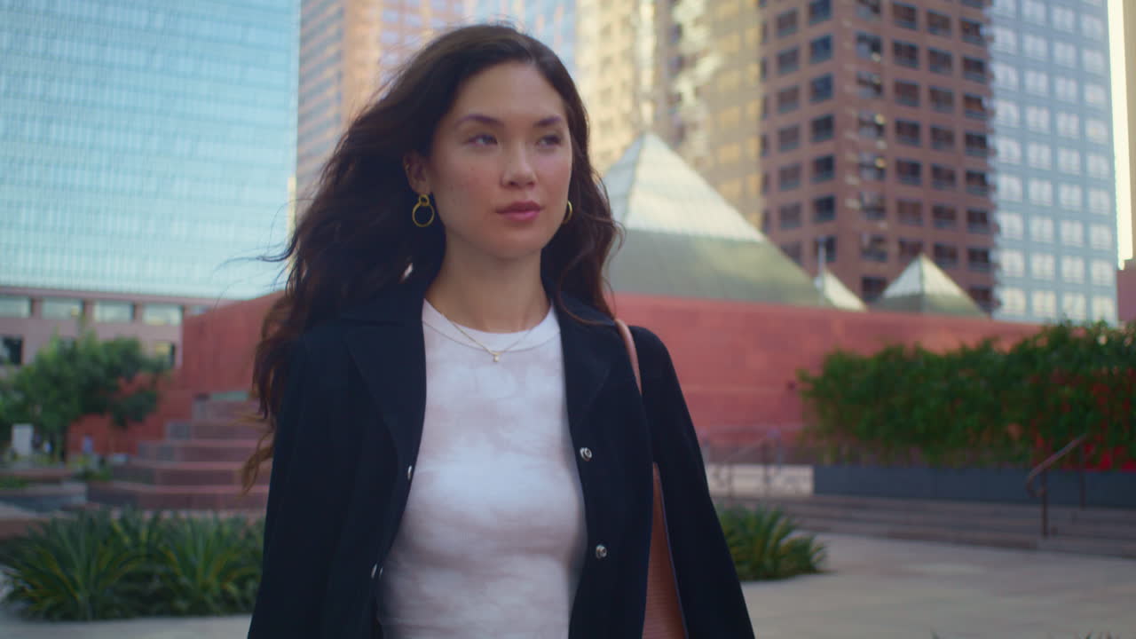 미소 짓는 소녀 가  ⁇ 고 있는 거리 를 가 ⁇ 게 찍습니다. 아시아 여성 은 도시 풍경 을 즐기고 있습니다.