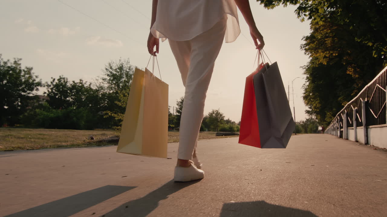 쇼핑 패키지를 들고 길을 걷는 여자