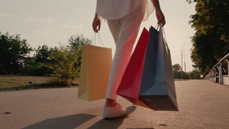 woman with shopping packages walks down the street