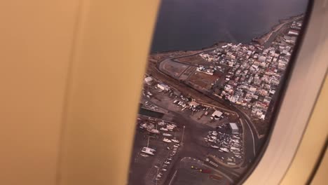 aerial view from an airplane window as it departs heraklion airport, revealing the coastal city and its surroundings on crete island, greece