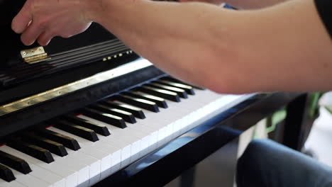 a musician opening the keyboard of a piano instrument to play notes at a concert