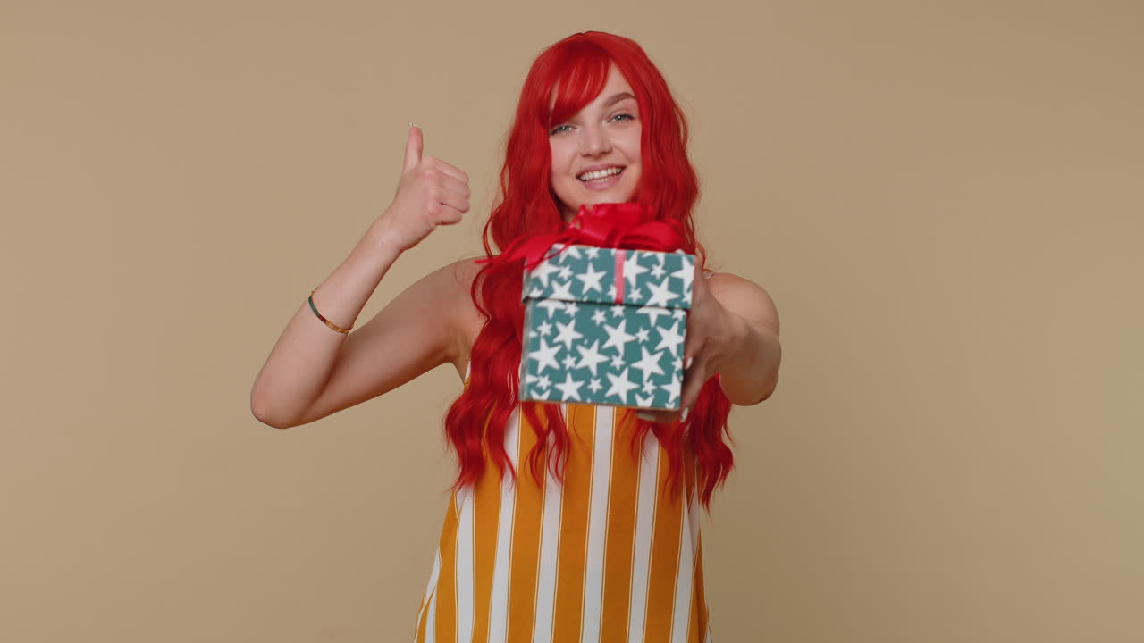 Ragazza rossa che presenta una scatola di regali di compleanno. Offerta di regalo avvolto. Bonus di carriera per festeggiare.