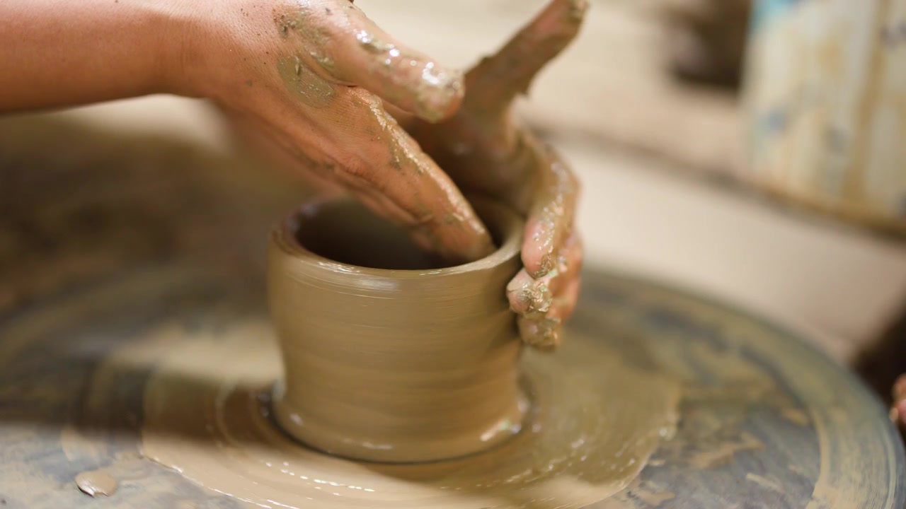 Primo piano di mani esperte che modellano un vaso di ceramica su un tornio a Nonthaburi, Thailandia