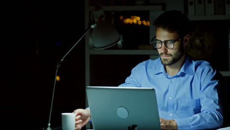 hombre de negocios tomando café mientras trabaja en una computadora portátil