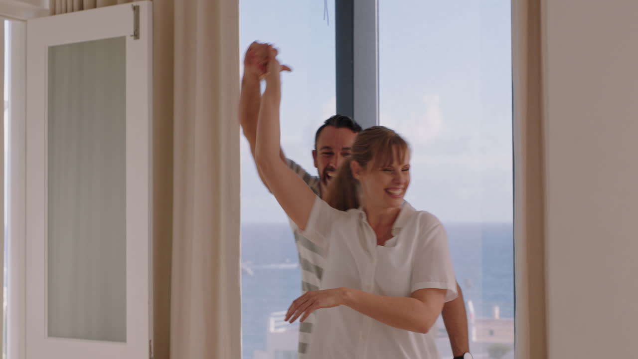 행복한 젊은 커플이 집에서 춤을 추고 함께 춤을 즐기고 즐겁게 관계를 축하합니다.