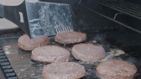 medium shot of hamburger patties grilling on a barbecue