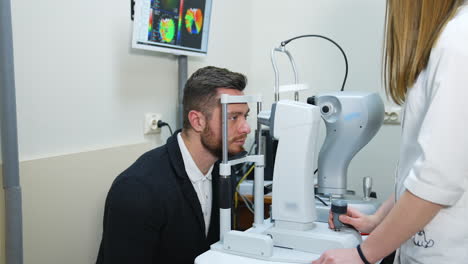 male patient in ophthalmology clinic. selective focus on man`s face while checking vision.