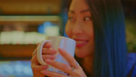 beautiful-Asian-oriental-female-girl-woman-model-in-cafe-restraurant-with-a-cup-of-beverage-drinking-talks,-chats,-dialogue,-conversation
