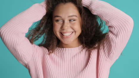 caucasian curly haired woman smiling to the camera.