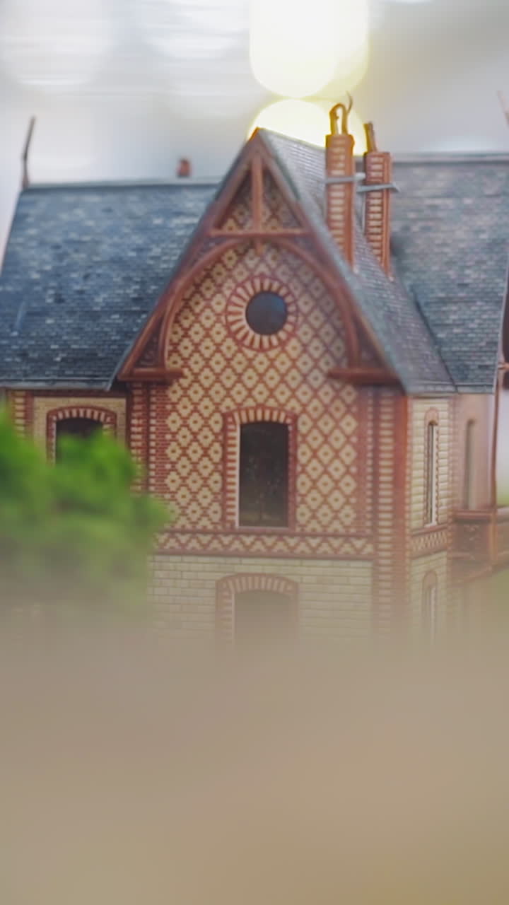 Tiny buildings in vintage style with arch on facade at old city model on stand in brightly lit hall of historical museum close view