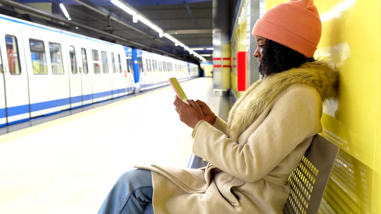 Woman using cellphone at a subway station