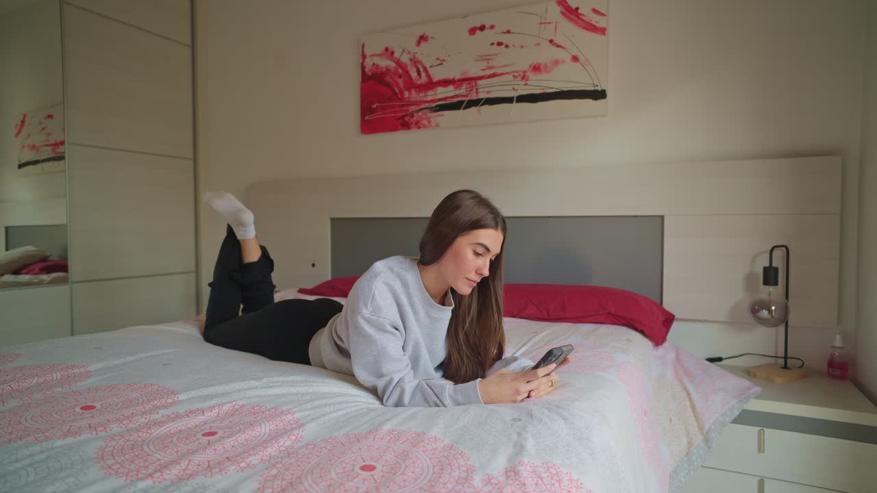 침실에서 스마트폰을 사용하는 여성