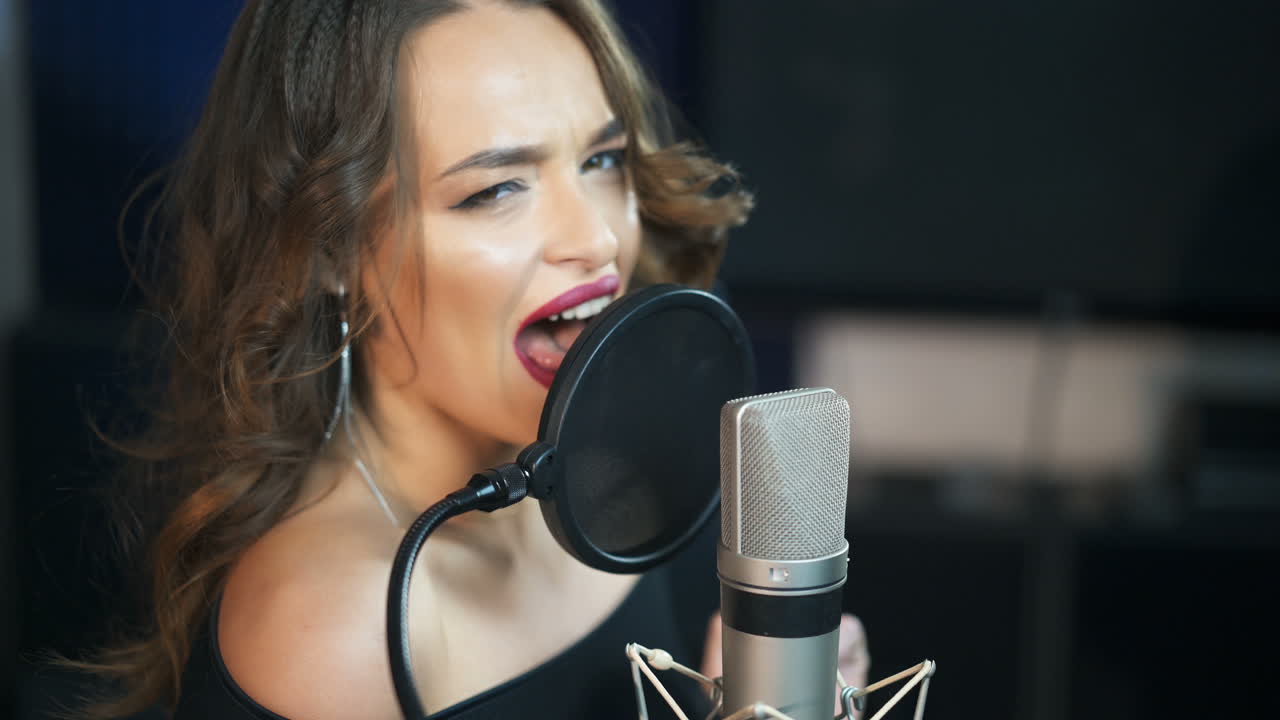Female singer recording a song in music studio. Recording Studio