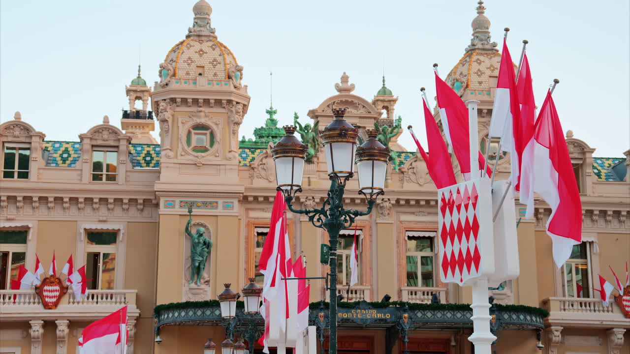 Monte Carlo, Monaco - October 24, 2024: The coat of arms of Monaco and multiple flags waving in front of the Monte Carlo Casino