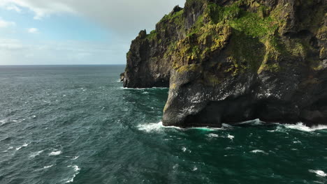 Aerial-view-approaching-the-Elephant-rock,-on-the-coast-of-sunny-Heimaey,-Iceland