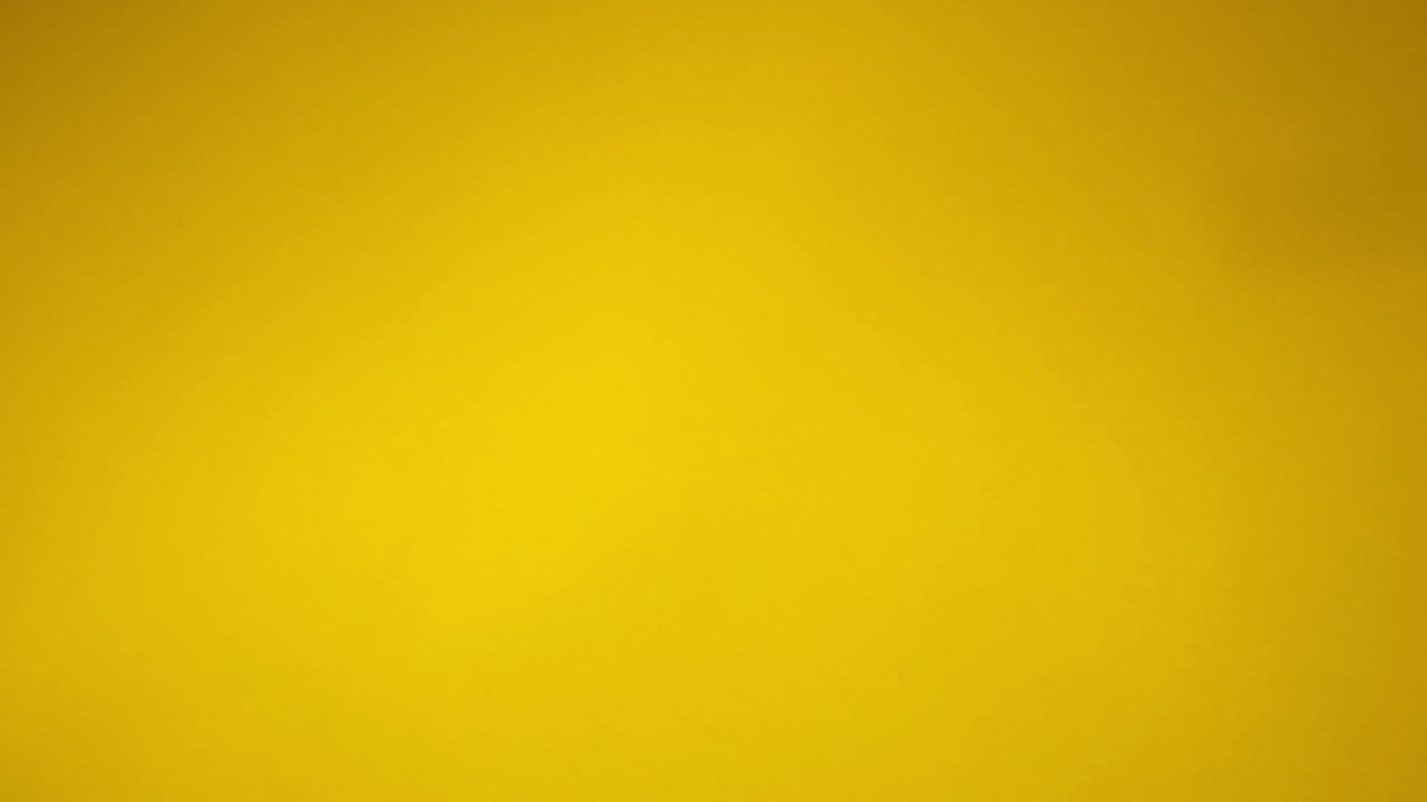 Coriandoli dorati che cadono su uno sfondo giallo.