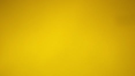 confeti dorado cayendo contra un fondo amarillo