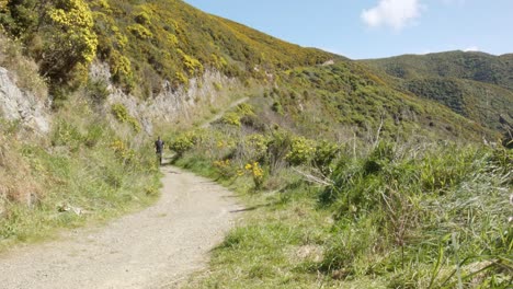 un excursionista de un día caminando por un camino de grava empinado hacia la cámara