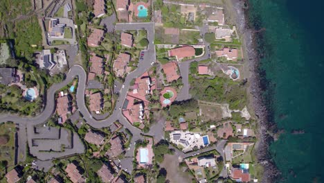 aerial top-down rotating descend shot of the residential village near catania, sicily, italy