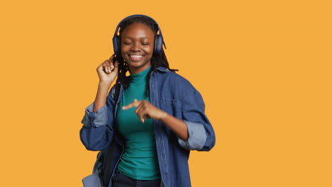 Joyous-woman-doing-happy-dance,-listening-music,-studio-background