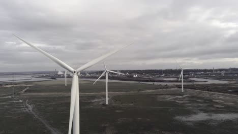 sustainable electrical wind turbines spinning on england farmland parallax dolly right