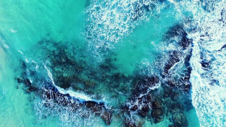 colpo di drone aereo 4k di bellissimo oceano blu tropicale con onde che si infrangono sulle rocce