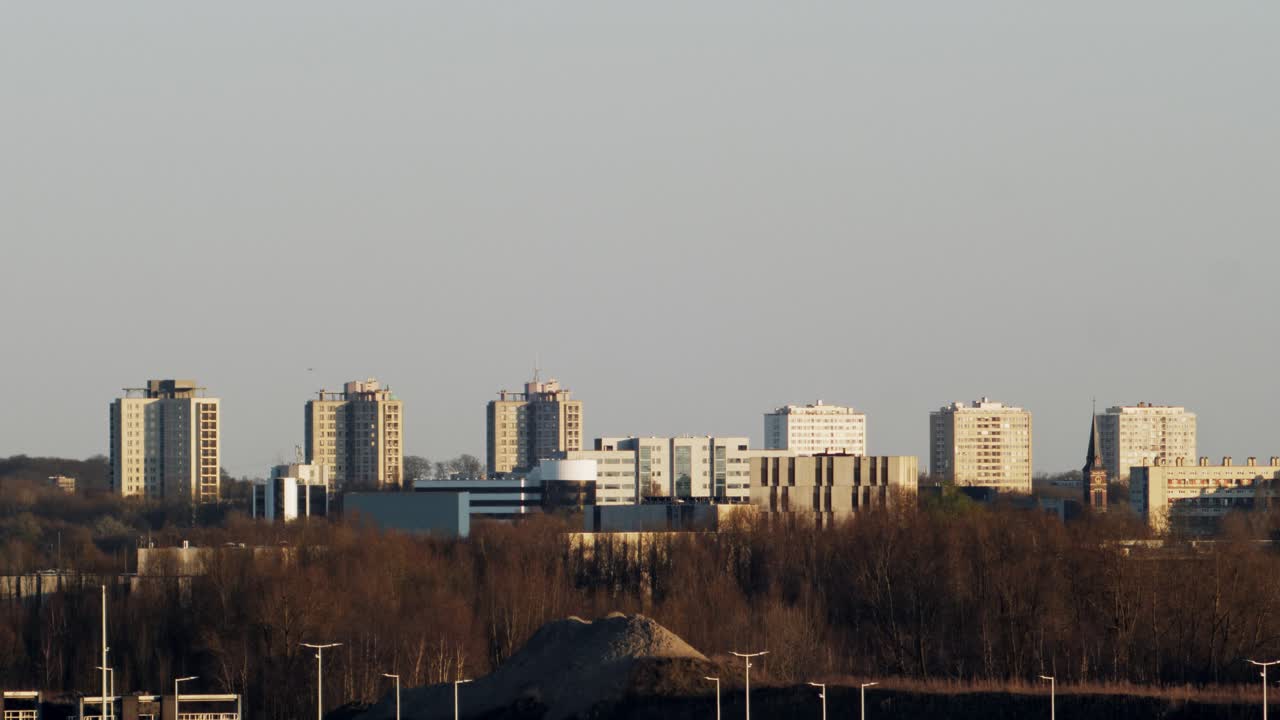 Wide-angle view of six residential towers in Kiel, Antwerp, Belgium with a mix of modern and historic architecture under warm sunlight