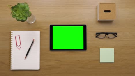 overhead of woman touching digital tablet at wooden desk