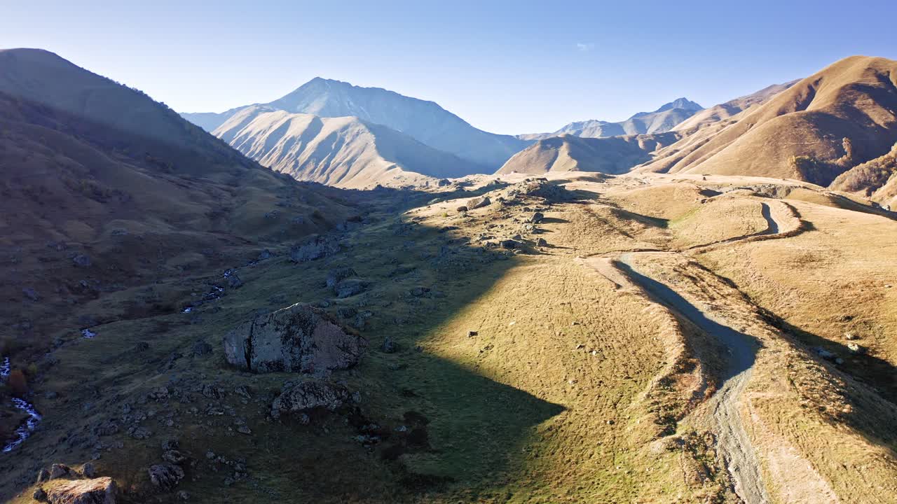 vista aérea de un valle montañoso iluminado por la puesta de sol en la región georgiana de tusheti