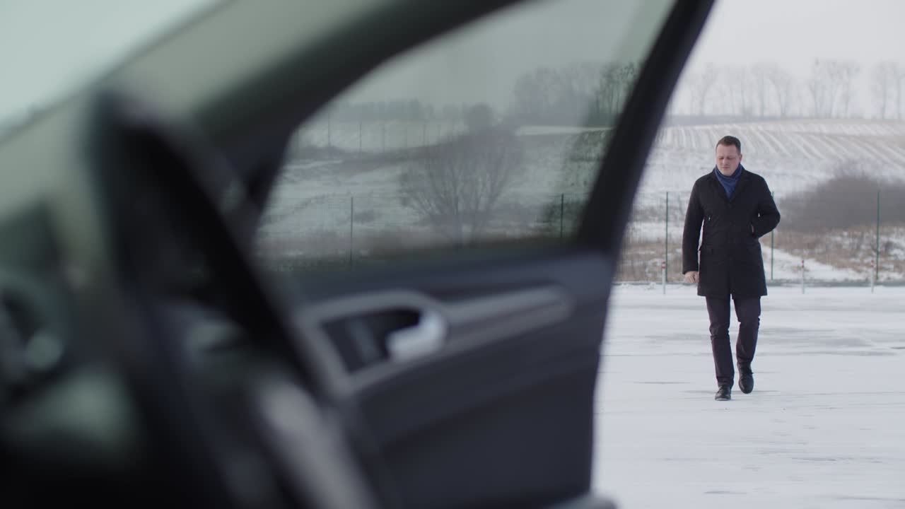 한 남자가 눈 인 도로에서 차로 간다.